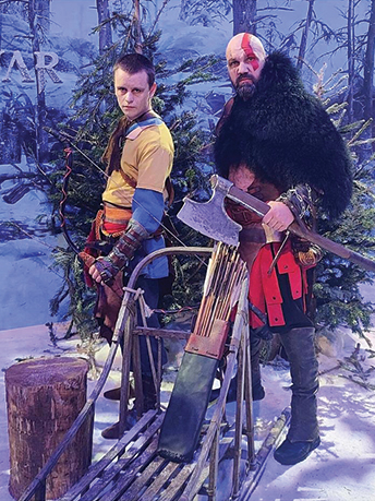 Deux hommes posant dans un décor enneigé, portant des pièces d'armures en cuir, l'un armé d'un arc et l'autre d'une hache.